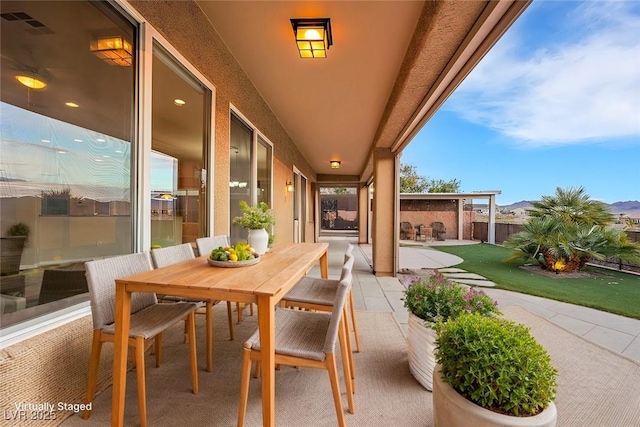 view of patio featuring outdoor dining area and fence