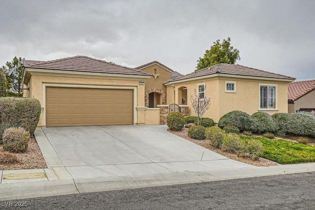 mediterranean / spanish home featuring driveway, a tiled roof, an attached garage, and stucco siding