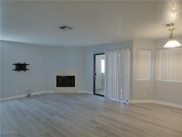 5044 S Rainbow Blvd Unit 106, Las Vegas, NV 89118 - unfurnished living room with a fireplace, wood finished floors, visible vents, and baseboards