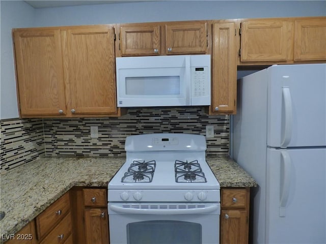 5044 S Rainbow Blvd Unit 106, Las Vegas, NV 89118 - kitchen featuring decorative backsplash, white appliances, and light stone counters