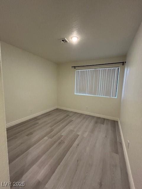 5044 S Rainbow Blvd Unit 106, Las Vegas, NV 89118 - unfurnished room featuring baseboards, wood finished floors, and visible vents