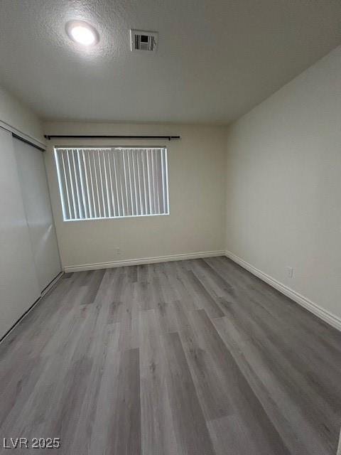 5044 S Rainbow Blvd Unit 106, Las Vegas, NV 89118 - spare room featuring baseboards, wood finished floors, visible vents, and a textured ceiling