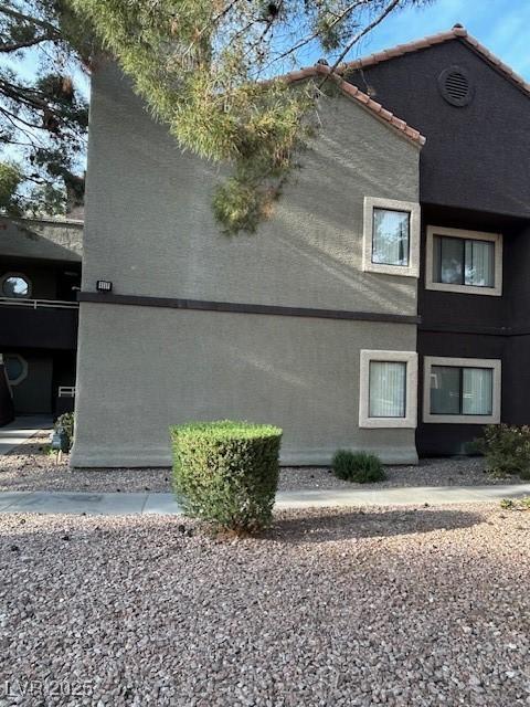 5044 S Rainbow Blvd Unit 106, Las Vegas, NV 89118 - view of side of property with stucco siding and a tile roof