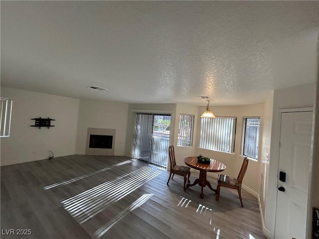 5044 S Rainbow Blvd Unit 106, Las Vegas, NV 89118 - dining area with baseboards, wood finished floors, a textured ceiling, and a fireplace