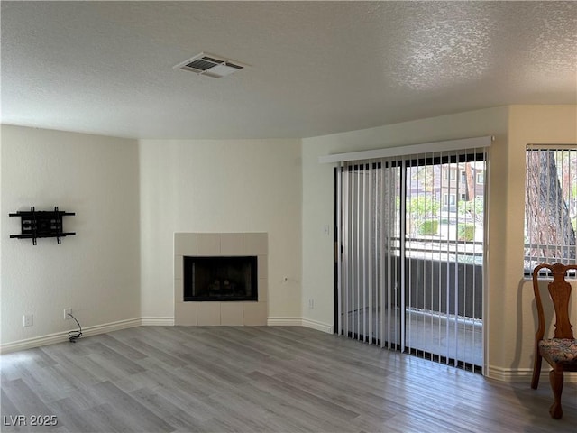 5044 S Rainbow Blvd Unit 106, Las Vegas, NV 89118 - unfurnished living room with baseboards, wood finished floors, visible vents, and a textured ceiling
