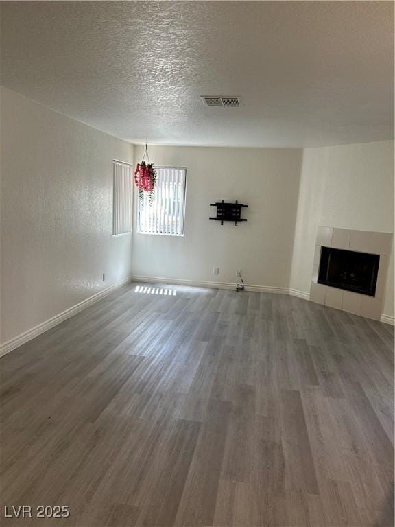 5044 S Rainbow Blvd Unit 106, Las Vegas, NV 89118 - unfurnished living room with baseboards, wood finished floors, visible vents, and a tiled fireplace