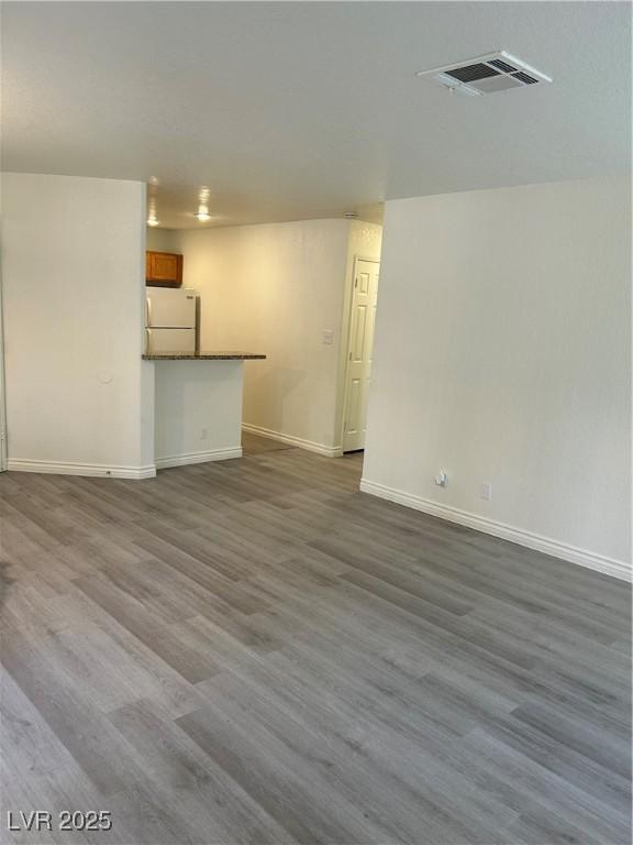5044 S Rainbow Blvd Unit 106, Las Vegas, NV 89118 - unfurnished living room featuring baseboards, visible vents, and dark wood-style flooring