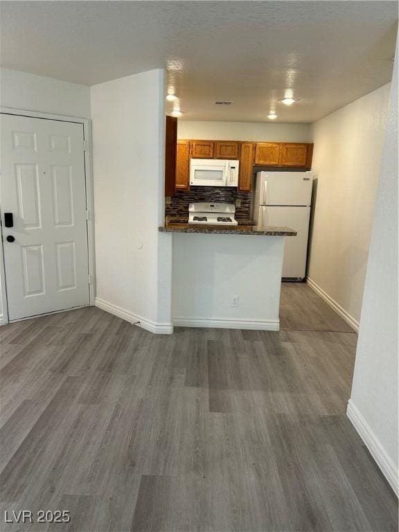 5044 S Rainbow Blvd Unit 106, Las Vegas, NV 89118 - kitchen with baseboards, brown cabinets, white appliances, and dark wood-style floors