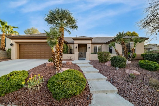 ranch-style home with a garage, concrete driveway, and stucco siding