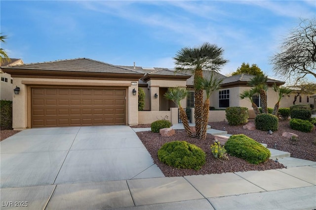 view of front of home featuring driveway, a tiled roof, a garage, and stucco siding