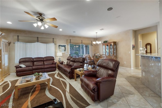 living area with light tile patterned floors, ceiling fan with notable chandelier, and recessed lighting