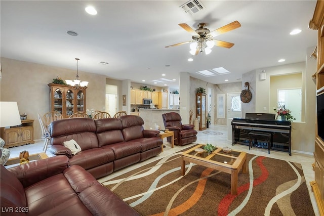 living room featuring recessed lighting, visible vents, baseboards, and ceiling fan with notable chandelier