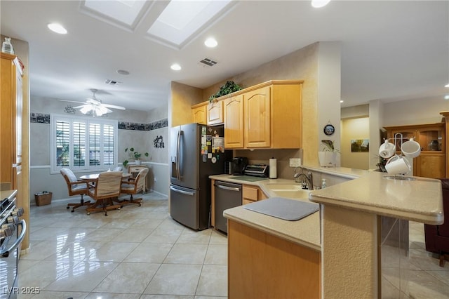 kitchen featuring a peninsula, visible vents, appliances with stainless steel finishes, and a sink