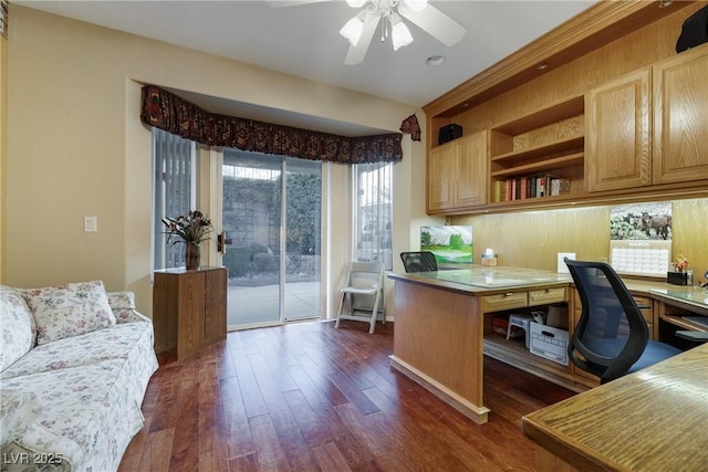 home office featuring dark wood-style floors, built in desk, and a ceiling fan