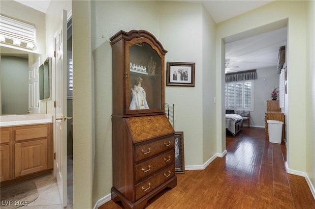 corridor featuring wood finished floors and baseboards