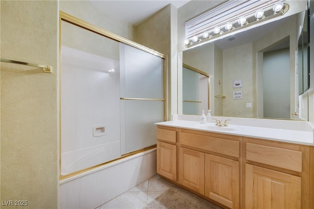 bathroom featuring enclosed tub / shower combo, vanity, and tile patterned floors