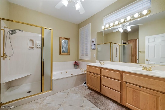 full bath with double vanity, ceiling fan, tile patterned floors, a shower stall, and a sink