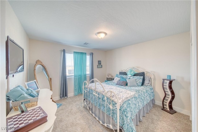 bedroom with light carpet, visible vents, baseboards, and a textured ceiling