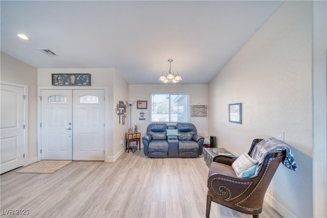 interior space with baseboards, light wood-type flooring, visible vents, and an inviting chandelier