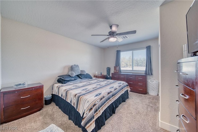 carpeted bedroom featuring a ceiling fan, visible vents, and a textured ceiling