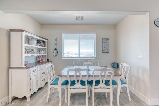 dining room with baseboards, visible vents, and light wood-style floors