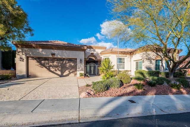 view of front of property featuring driveway, a tile roof, a garage, and stucco siding