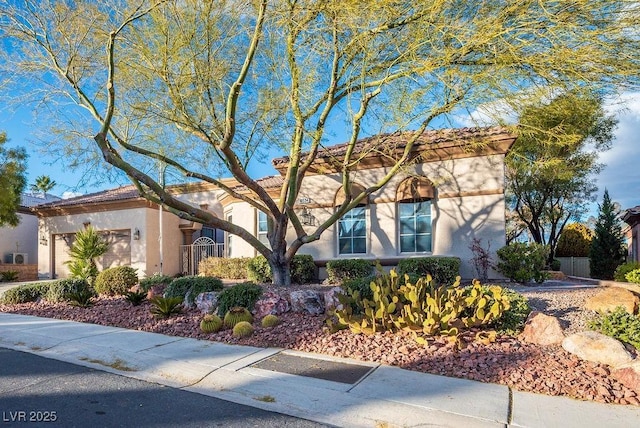 view of front of home featuring a garage, fence, and stucco siding