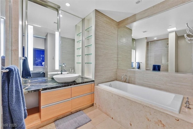 full bathroom featuring tile patterned flooring, vanity, tile walls, a tile shower, and a bath