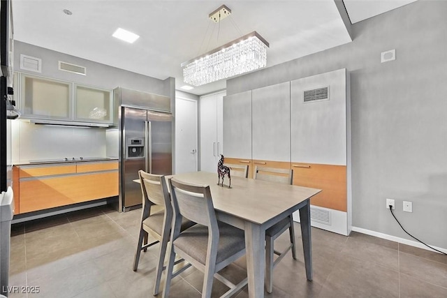 tiled dining room featuring visible vents and baseboards