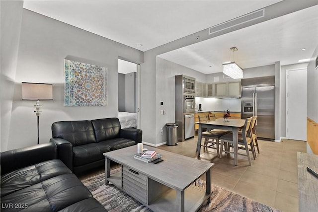 living room featuring light tile patterned floors, visible vents, and baseboards