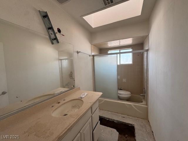 bathroom with toilet, visible vents, shower / bath combination with glass door, and vanity