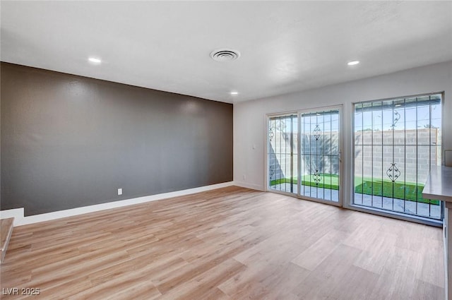 empty room featuring recessed lighting, visible vents, baseboards, and light wood finished floors