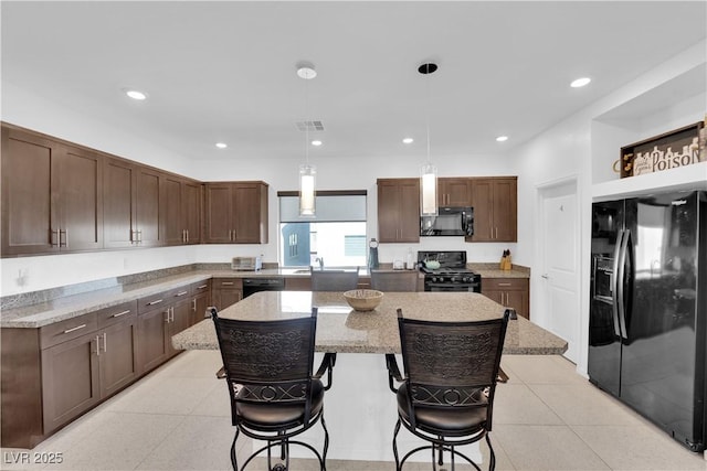 kitchen featuring a center island, light tile patterned floors, recessed lighting, visible vents, and black appliances