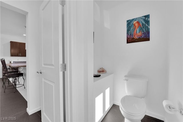 bathroom with toilet and baseboards