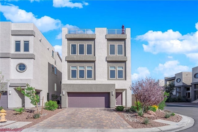 view of front of house with a garage, decorative driveway, and stucco siding