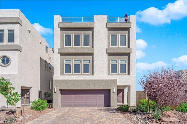 view of front facade featuring a garage, decorative driveway, and stucco siding