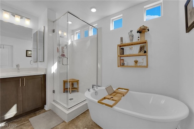 full bath featuring a freestanding bath, a wealth of natural light, a stall shower, and vanity