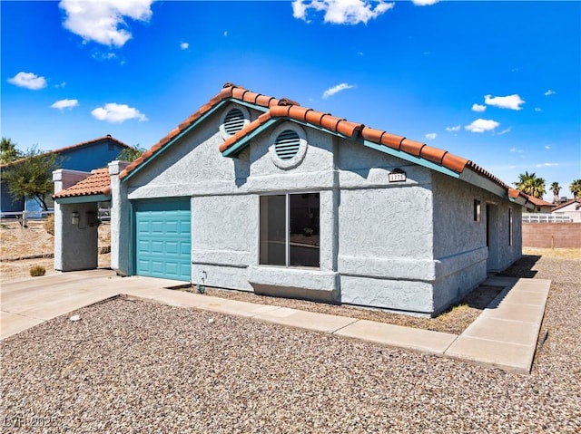 view of front of home with a garage, driveway, and stucco siding