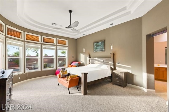 bedroom featuring visible vents, a raised ceiling, and light colored carpet