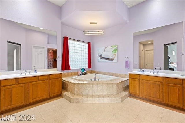 full bath with two vanities, a garden tub, a sink, and tile patterned floors