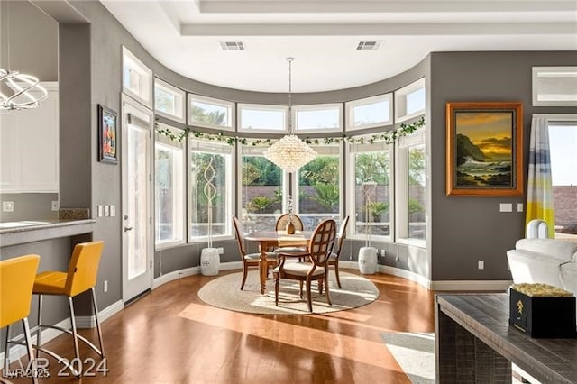 sunroom / solarium with plenty of natural light, visible vents, and a chandelier