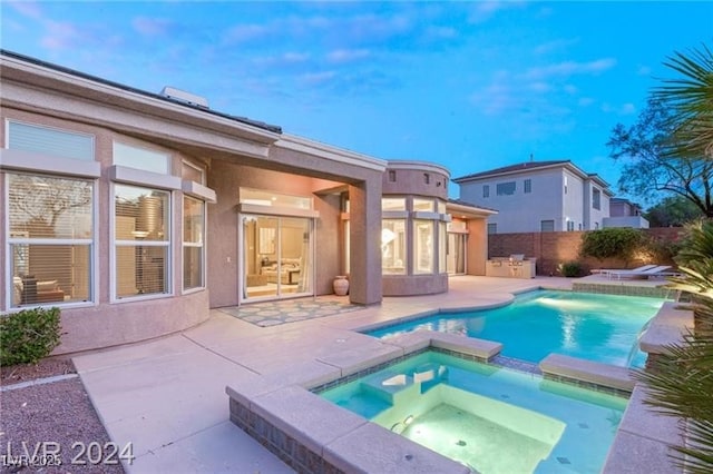 view of swimming pool featuring a patio area, a pool with connected hot tub, and fence