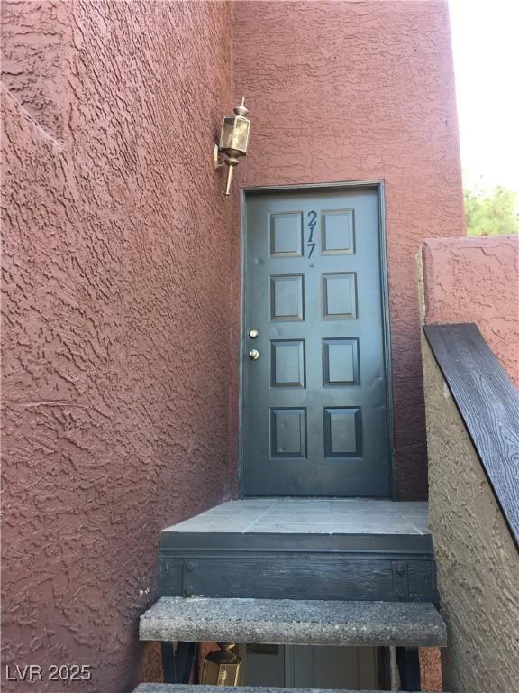 doorway to property featuring stucco siding