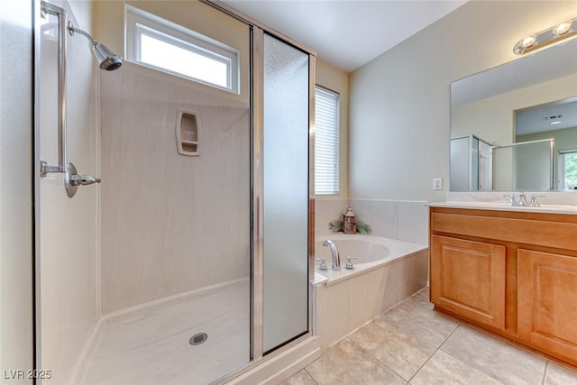 full bathroom with tile patterned flooring, a garden tub, a shower stall, and vanity