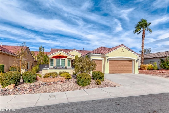 view of front of property featuring driveway, an attached garage, a tile roof, and stucco siding