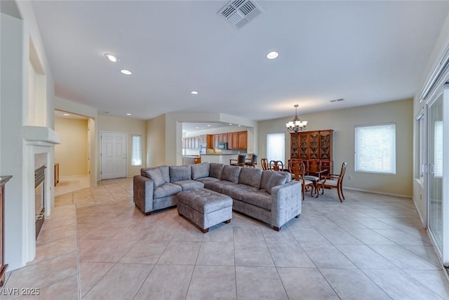 living room with a chandelier, light tile patterned flooring, recessed lighting, visible vents, and baseboards