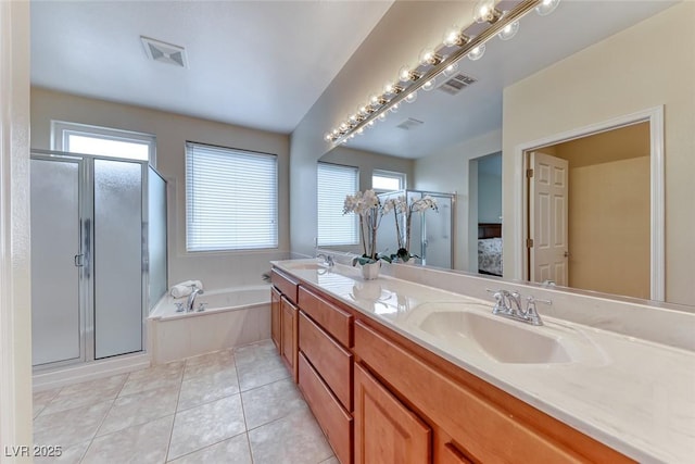 full bathroom featuring a stall shower, tile patterned flooring, a sink, and a bath