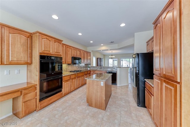 kitchen featuring decorative backsplash, a kitchen island, light stone countertops, a peninsula, and black appliances