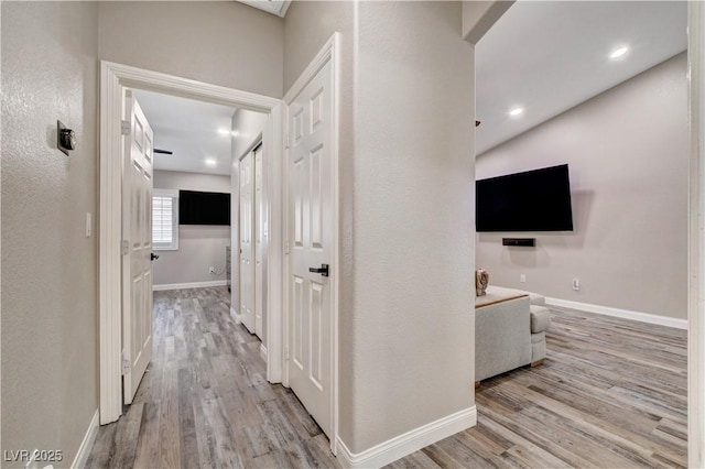 hallway with recessed lighting, baseboards, and wood finished floors