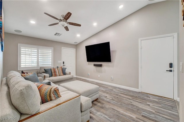 living room featuring lofted ceiling, visible vents, a ceiling fan, baseboards, and light wood finished floors